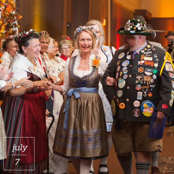 Människor i traditionella tyrolerkläder som dirndl och lederhosen under en festlig tillställning.