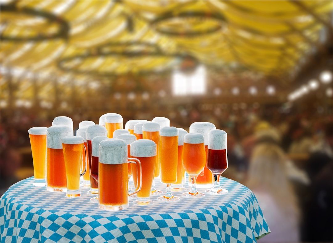 Olika sorters ölglas fyllda med skummande öl på ett bord under Oktoberfest.